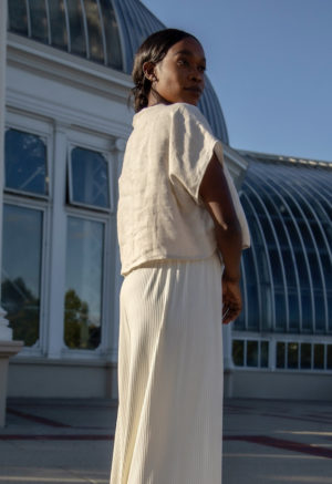 Side view of straight size model wearing Boatneck Crop Top in Oatmeal Linen.