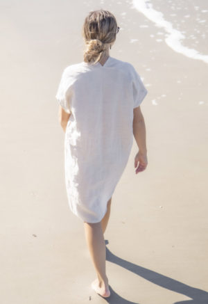 Back view of straight size model wearing Double V Kaftan in Oatmeal Linen.