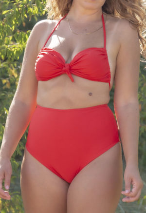 Close-up front view of straight size model in the Valentine Halter Tie Top, standing in the sand between trees.