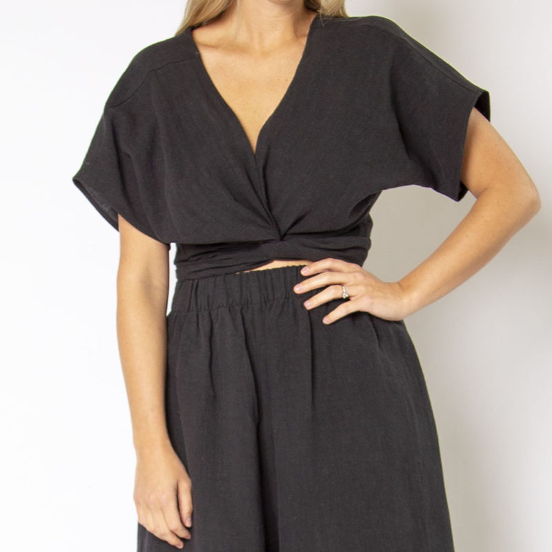Front view of straight size model wearing Black Linen Short Sleeve Tie Top and Black Linen Extra Wide-Leg Pant.