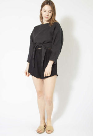 Front view of straight size model wearing Black Linen Long Sleeve Tie Top.