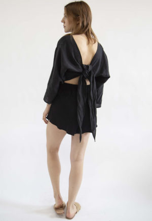 Back view of straight size model wearing Black Linen Long Sleeve Tie Top.