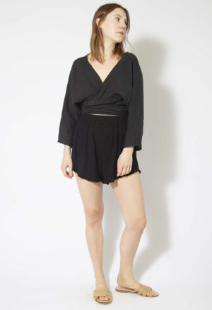 Front view of straight size model wearing Black Linen Long Sleeve Tie Top.