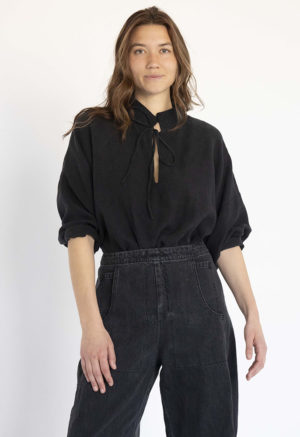 woman in black collar tie top with black wide-leg pants