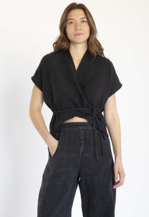 woman in black cropped wrap top and wide-leg black denim pants