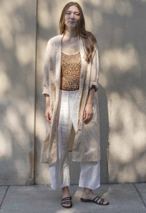 woman in leopard print tank top, white pants, tan sheer jacket