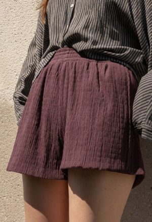 woman in dark chocolate brown shorts and black and white button-up shirt