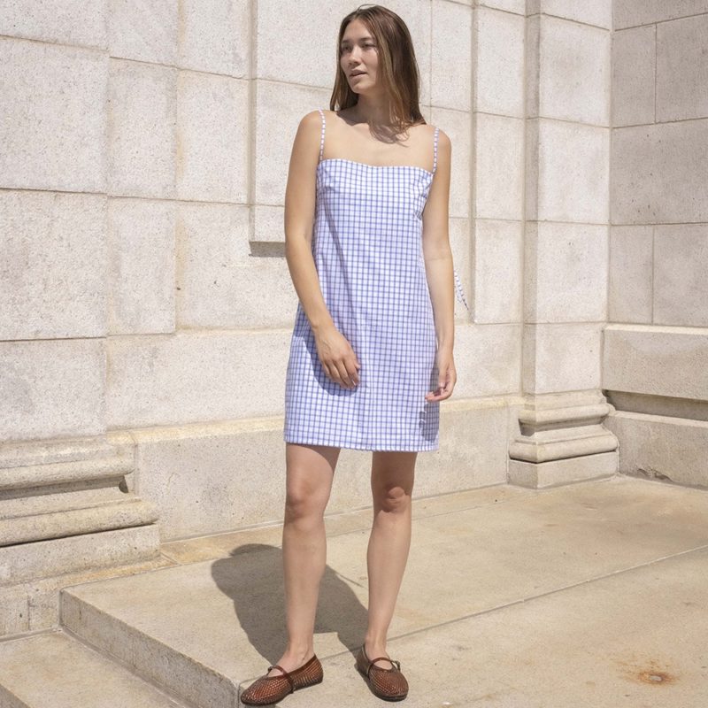 woman in white and blue window pane slip dress with brown jelly shoes