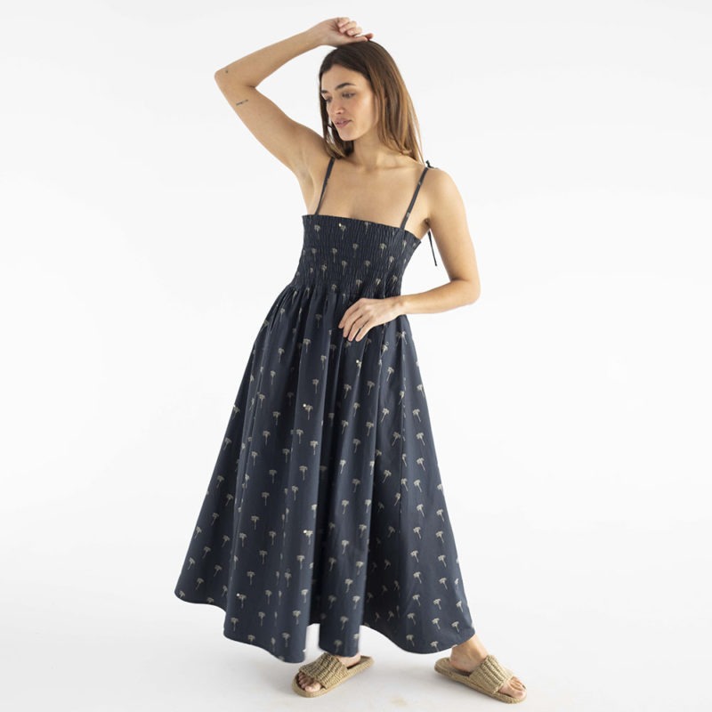 women in black spaghetti strap sundress with palm tree print