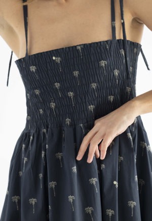 women in black spaghetti strap sundress with palm tree print
