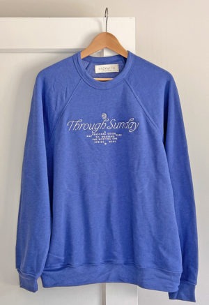 blue sweatshirt with white embroidered writing at chest