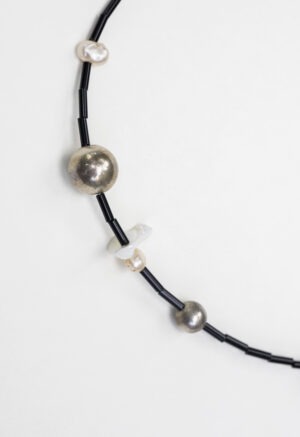 black necklace on white backdrop