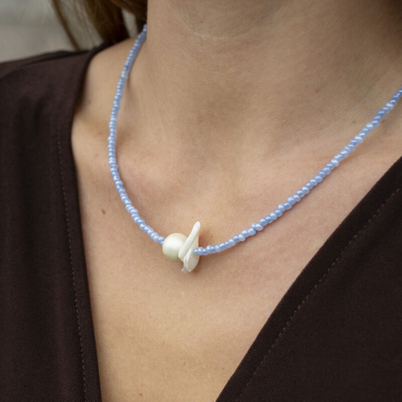 woman in blue pearl and shell necklace