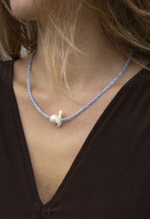 woman in blue pearl and shell necklace