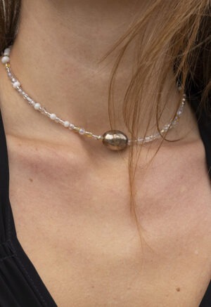 woman in black dress and beaded necklace