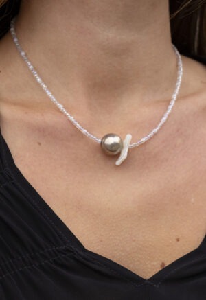 woman in black v-neck with silver and clear beaded necklace