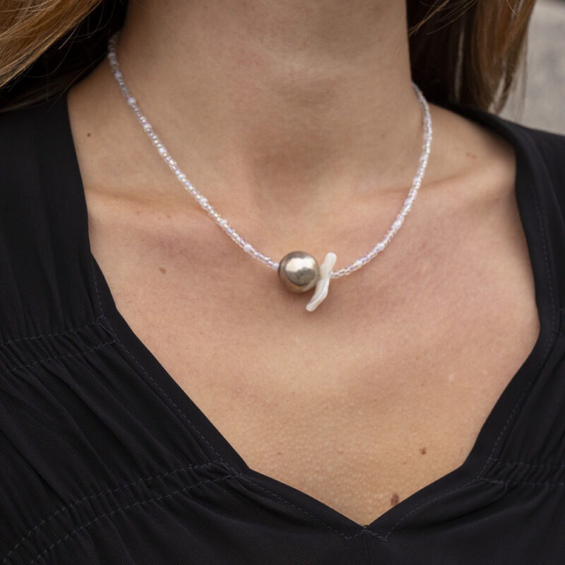 woman in black v-neck with silver and clear beaded necklace