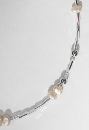 pearl and silver necklace on white backdrop