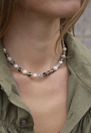 woman in green button-up with round beaded necklace
