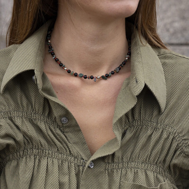 woman in green button-up with dark green and black beaded necklace