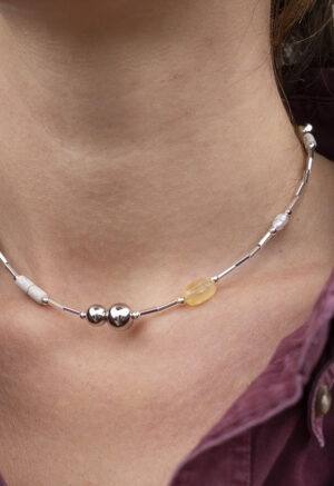 woman in maroon button-up and silver and stone necklace