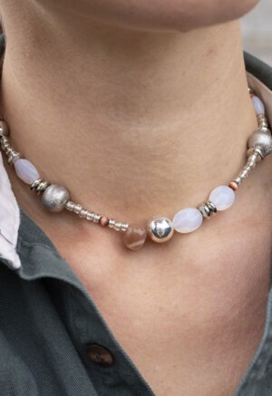 woman in green button-up with Necklace of silver, white rocks and red rocks