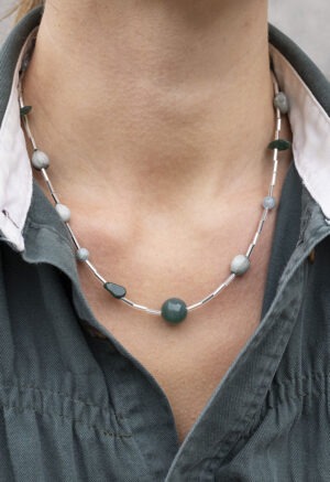 woman in green button-up shirt and beaded necklace