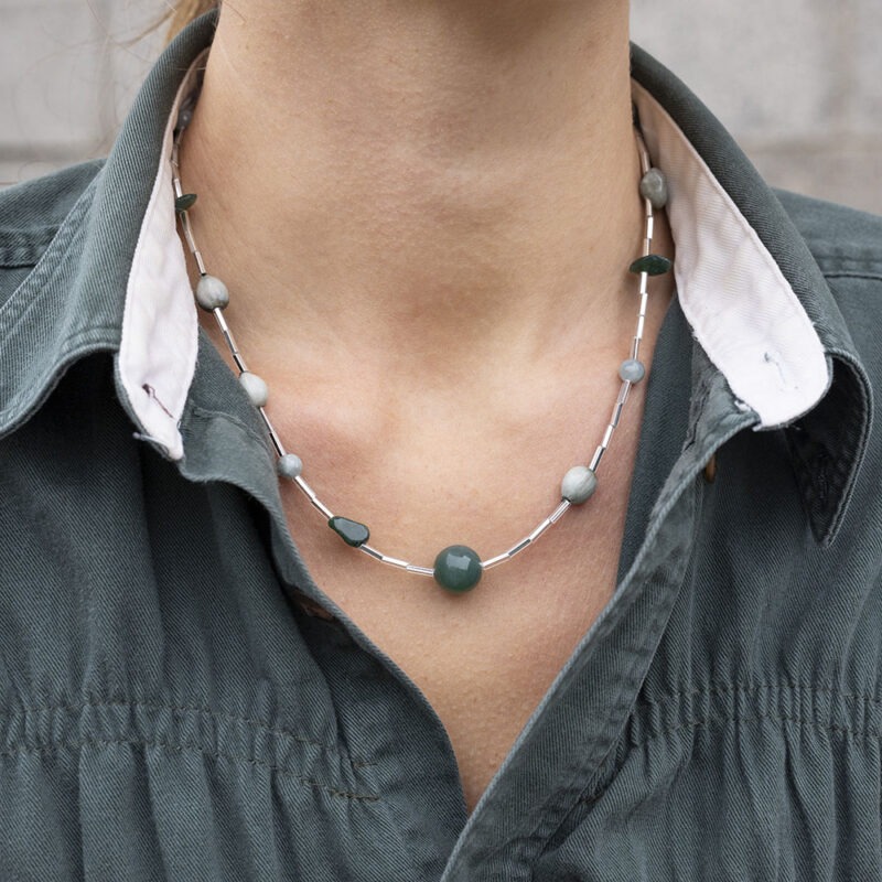 woman in green button-up shirt and beaded necklace