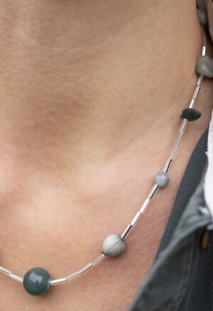 woman in green button-up shirt and beaded necklace
