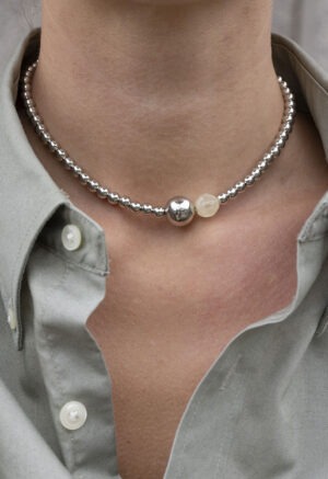woman wearing grey button-up with silver beaded necklace