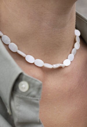 woman in grey shirt and pearl necklace