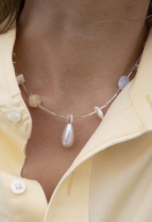 woman in yellow button-up and wearing a necklace