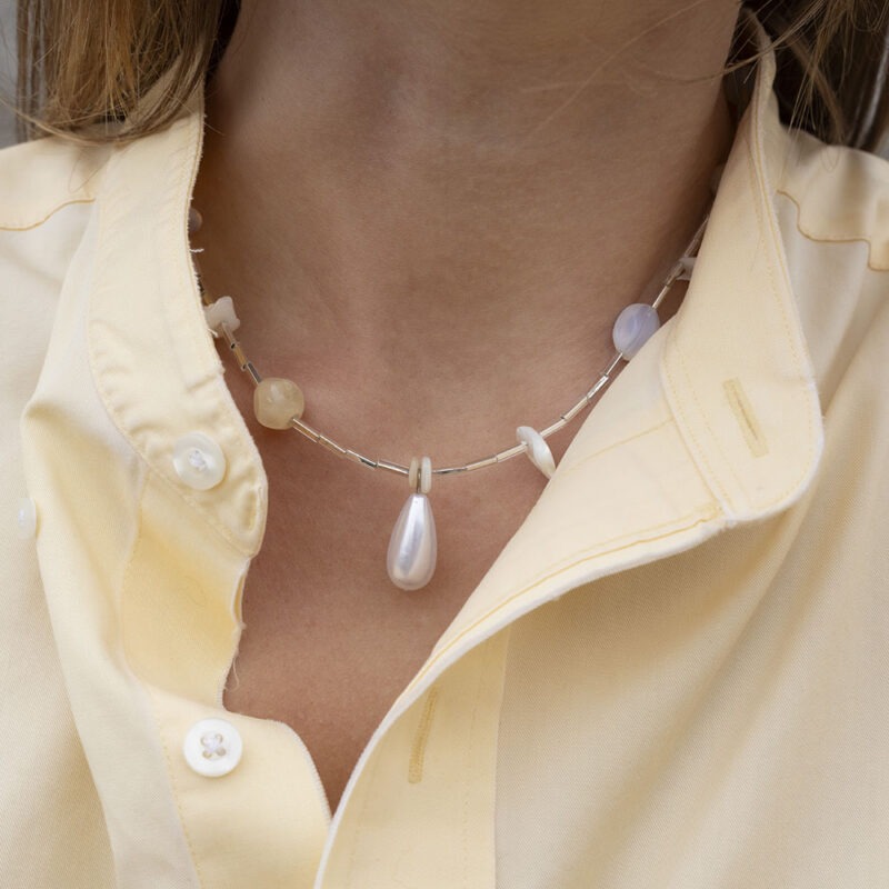 woman in yellow button-up and wearing a necklace