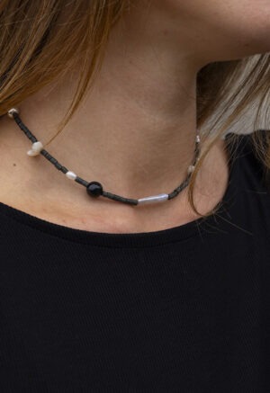 Woman wearing black necklace with black and pearl beads