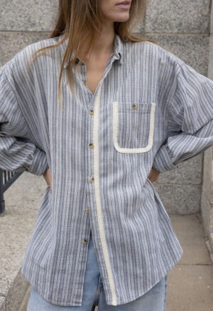 woman in blue and white stripe button-up and jeans