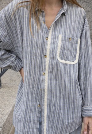 woman in blue and white stripe button-up and jeans
