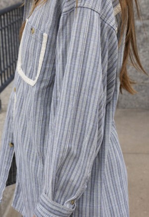 woman in blue and white stripe button-up and jeans