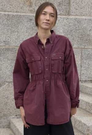 woman in maroon button-up and black trousers