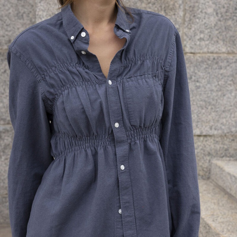 woman in dark grey button-up and black pants