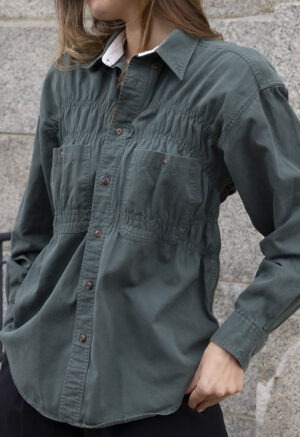 woman in green button-up and black trousers