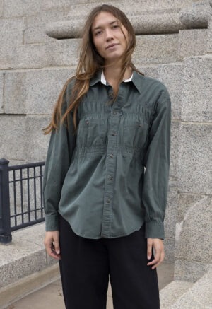 woman in green button-up and black trousers