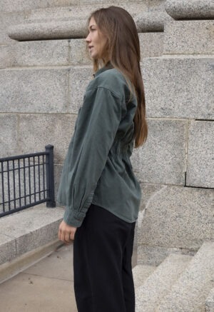 woman in green button-up and black trousers