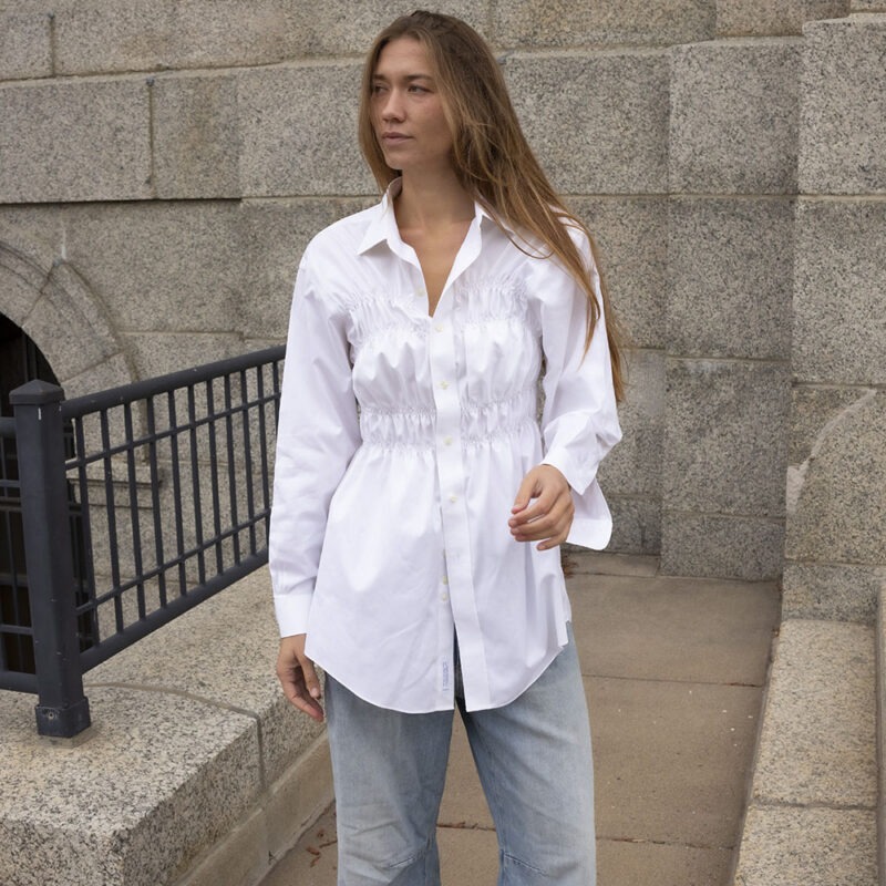 woman in white button-up and jeans