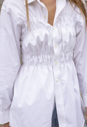 woman in white button-up and jeans
