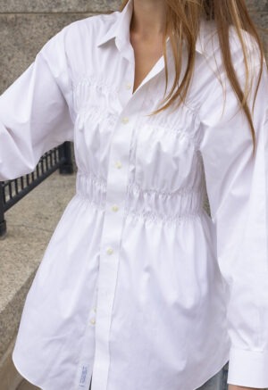 woman in white button-up and jeans