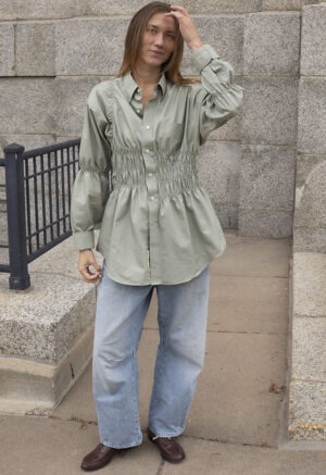 woman in tan button-up and jeans
