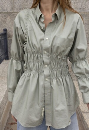 woman in tan button-up and jeans
