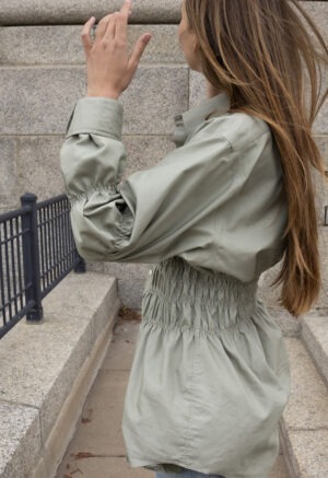 woman in tan button-up and jeans