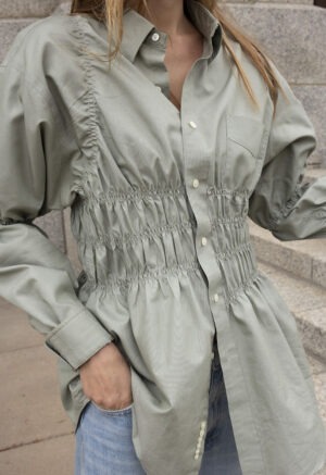 woman in tan button-up and jeans