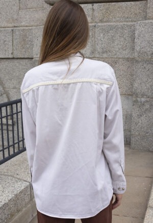 woman in cream button-up and brown pants